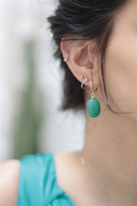 A Woman with Piercings and a Green Earring · Free Stock Photo