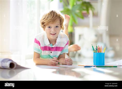 Child drawing lying on the floor. Kid painting rainbow. Online remote learning arts and crafts ...