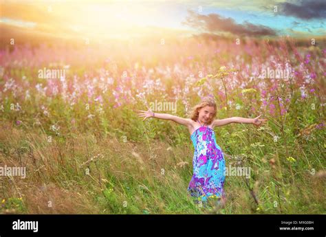 joyful dancing girl in a field of flowers Stock Photo - Alamy