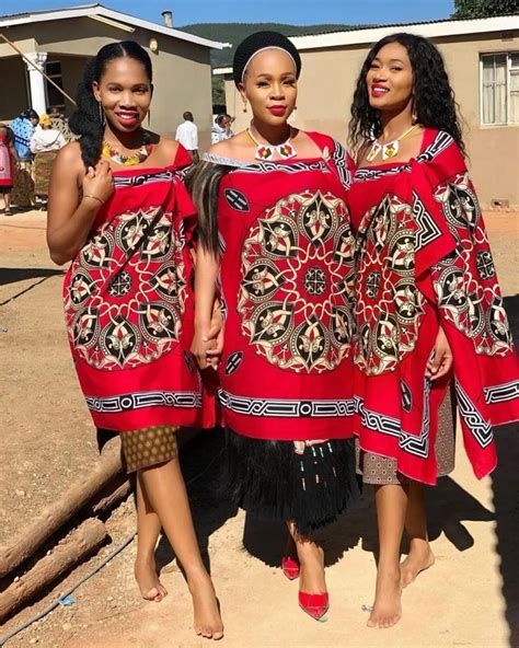 three women in red dresses standing next to each other