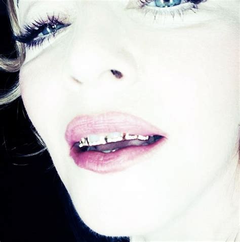 Madonna shows off gold and diamond 'grillz' on her teeth and poses with sword in her mouth ...