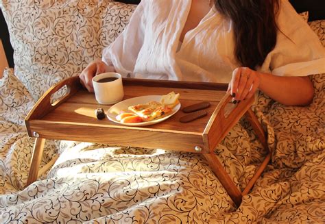 a woman is sitting in bed with her breakfast tray