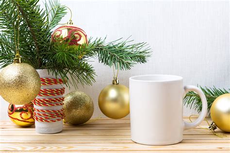 White coffee mug mockup with golden Christmas ornaments