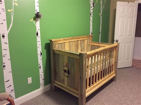 Rustic baby crib made from beetle kill pine and featuring a wood burned design on each end panel ...