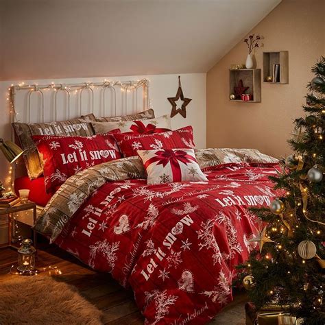 a bedroom decorated for christmas with red and white bedding, lights and a tree