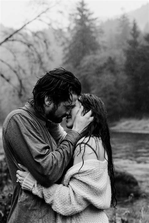 a man and woman kissing in front of a river