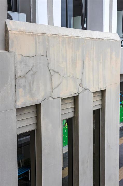 A close-up view of the concrete wall background shows the cracks of an old contemporary building ...