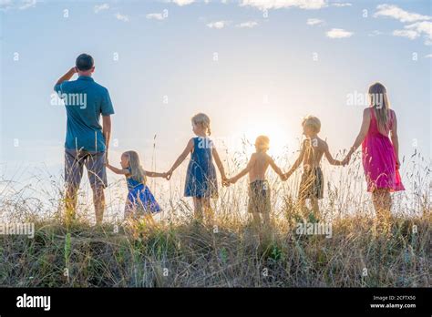 A large family is standing holding hands against the background of the ...