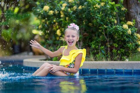 Little Girl Playing and Spraying Water in Swimming Pool Outdoors at ...