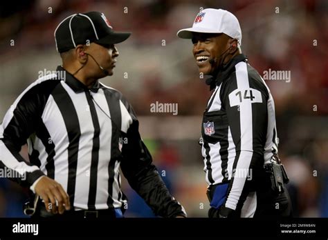 Referee Shawn Smith (14) and down judge Patrick Holt (106) converse during an NFL football game ...