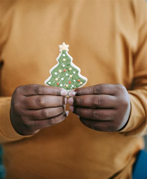 Black man with gingerbread in form of Christmas tree · Free Stock Photo