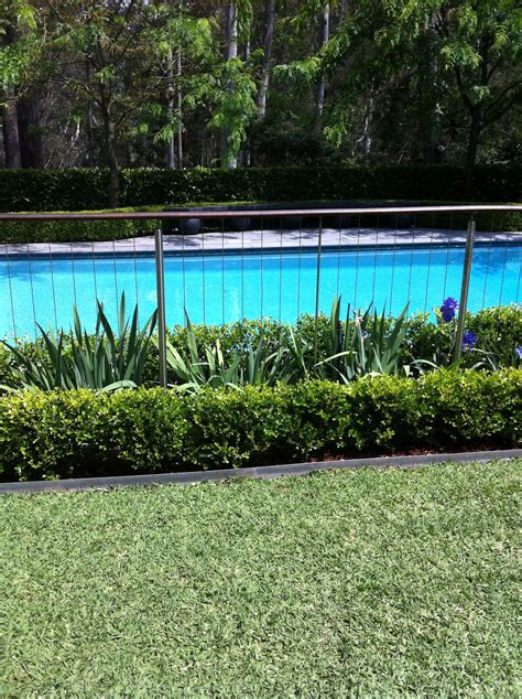 Really like this subtle pool fence with landscaping on both sides ...