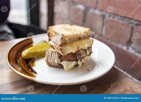 A Delicious Melted-cheese Sandwich with a Cucumber on a White and Brown ...