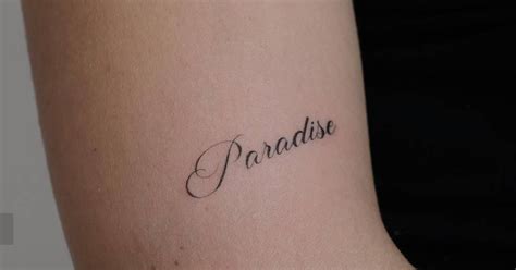 Tattoo of the word "paradise" located on the upper arm.