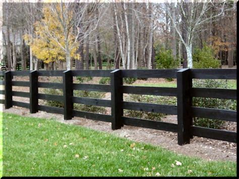 a black fence in front of some trees