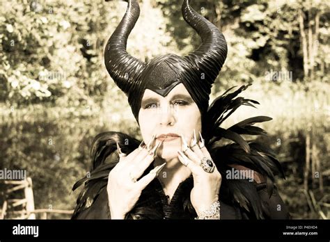 Evil fable queen with evil, malevolent and maleficent black horns, crow feather cloak and ...