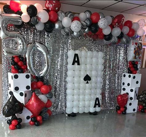 a casino themed party with balloons, dices and streamers in the shape ...