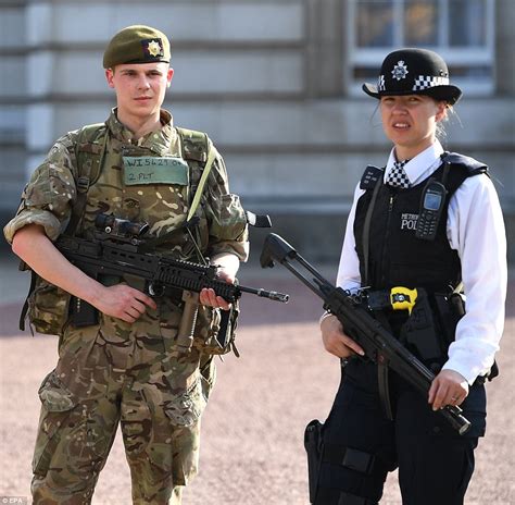 A British soldier stands guard next to a police officer. Armed soldiers and police officers have ...