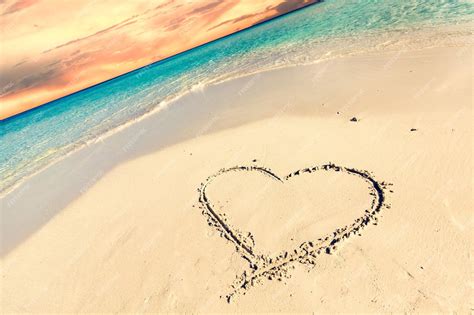 Premium Photo | Heart on sand on tropical beach at sunset