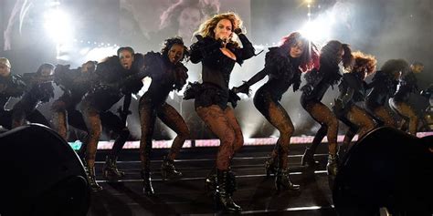 the singer performs on stage in front of her band, including dancers ...