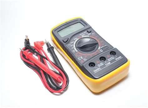 Digital multimeter with probes and display on a white background ...