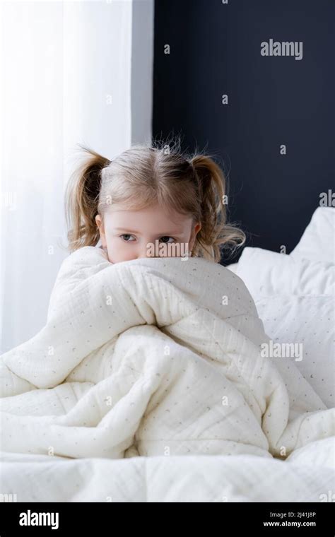 scared girl sitting on bed and obscuring face with white blanket Stock Photo - Alamy