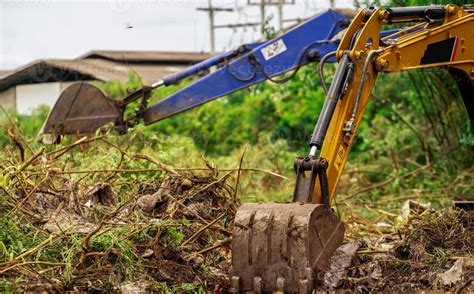 Backhoe digging soil at construction site. Bucket of backhoe digging ...