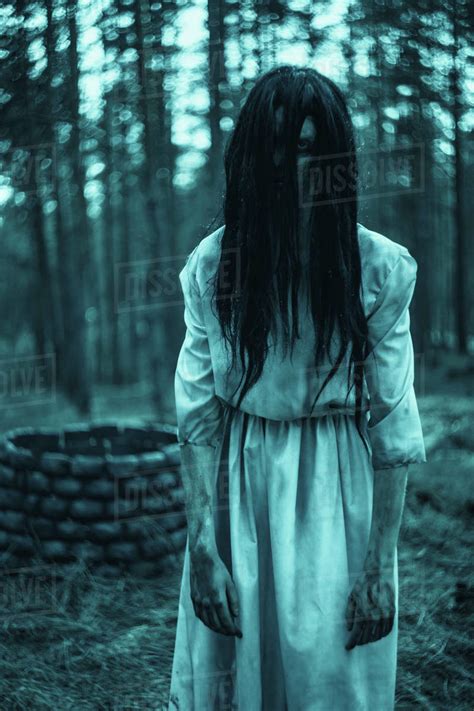 Girl with long black hair in image of scary ghost zombie stands among ...