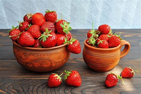 Premium Photo | Strawberries in pottery on a wooden table. side view