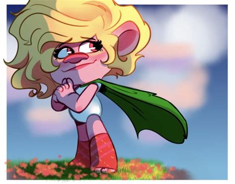 a cartoon character with blonde hair and blue eyes, wearing a green cape while standing in the grass