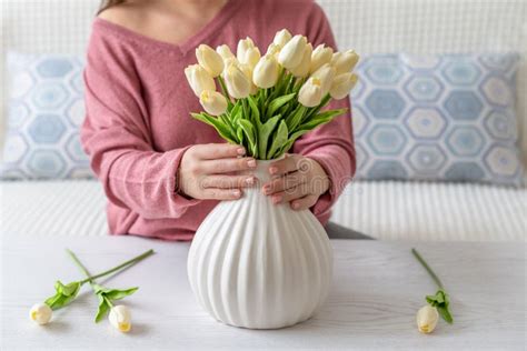 Woman Putting White Tulips Flowers in Vase Sitting at the Living Room ...