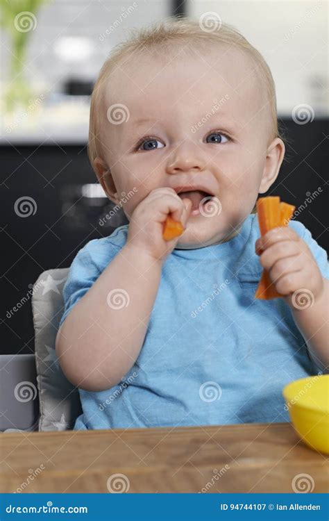 Happy Toddler Sitting at Table Eating Fresh Carrots Stock Image - Image ...