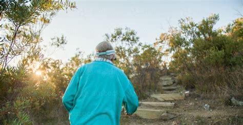 Image of Fit granny hiking up mountain steps in the early morning ...