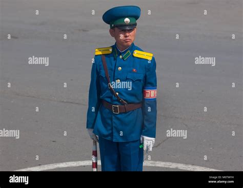 North Korean male traffic security officer in blue unform in the street ...