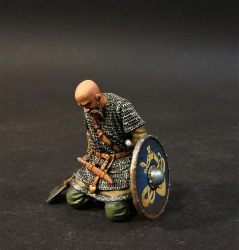 Kneeling Viking Warrior with axe and bald head (blue shield with yellow dragon pattern), the ...