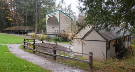 a small building in the middle of a park with trees and grass on both sides