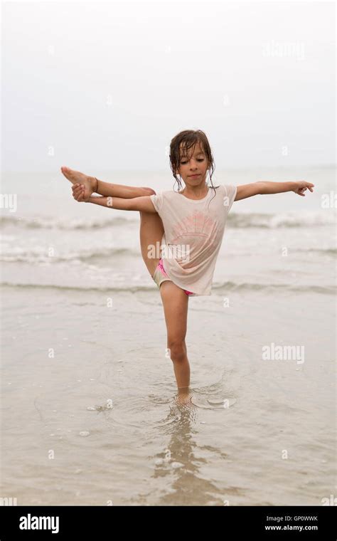 Little girl on a beach doing water gymnastics Stock Photo - Alamy