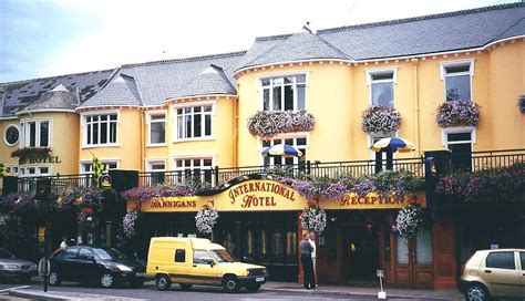 a yellow building with flowers on the balconies and cars parked in ...