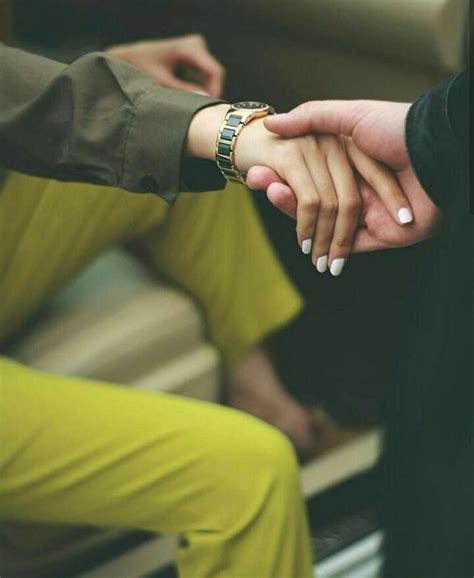 two people holding hands while sitting down
