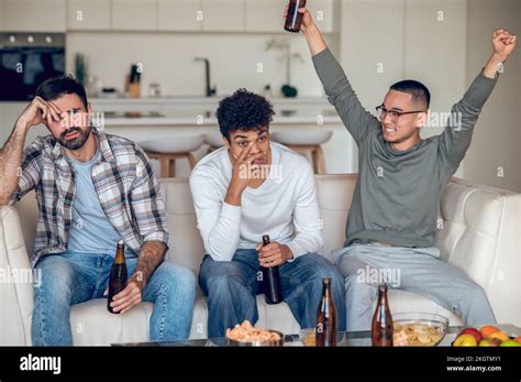 Pleased guy gloating over his upset friends Stock Photo - Alamy