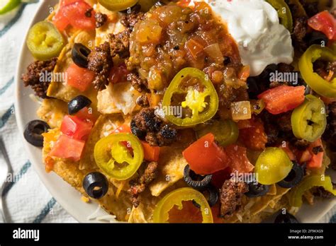 Homemade Cheesy Beef Nachos with Olives and Jalapenos Stock Photo - Alamy