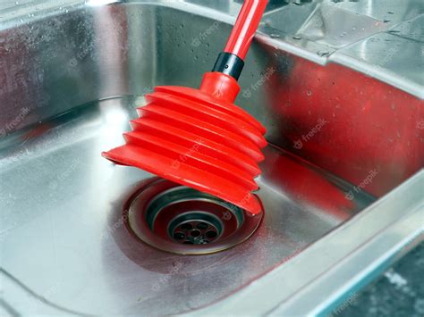 Premium Photo | Stainless kitchen sink and red plunger household work concept