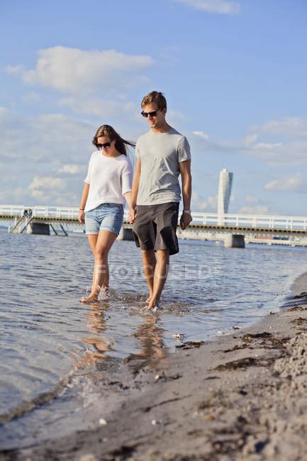 Couple holding hands while walking in sea — Enjoyment, fun - Stock Photo | #151403260