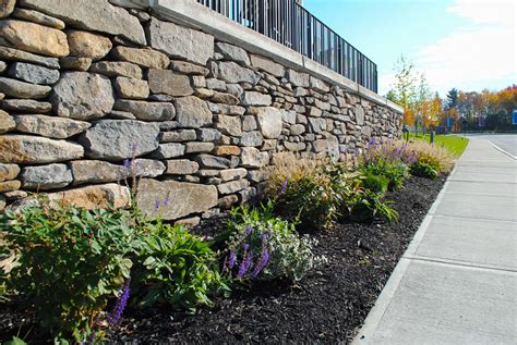 Stacked fieldstone walls with concrete cap