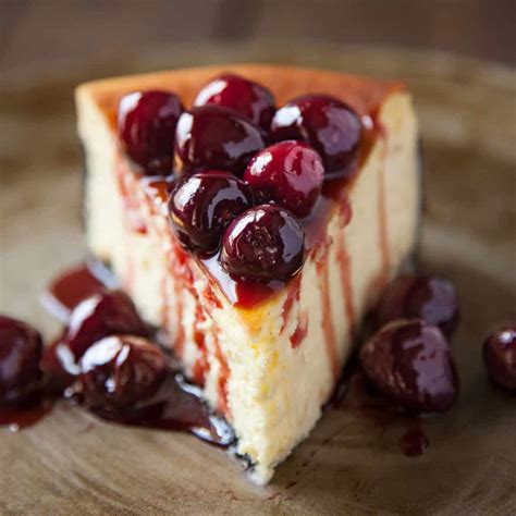 Classic New York Cheesecake with a Chocolate Cookie Crust and Roasted Cherries | Foodtasia