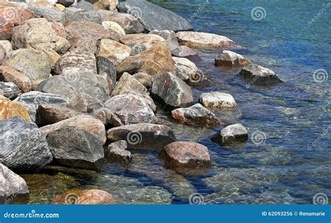 Rock Bed Along Shoreline of Clear Blue Lake Waters Stock Photo - Image ...