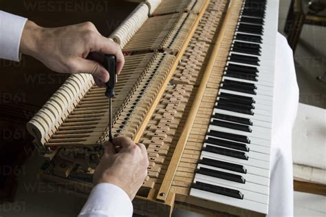 Piano tuner tuning grand piano stock photo