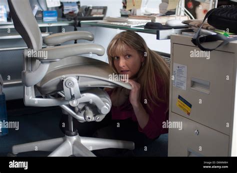 Woman hiding under her desk Stock Photo: 57003313 - Alamy