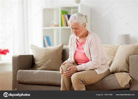 Senior woman suffering from pain in leg at home Stock Photo by ©Syda ...