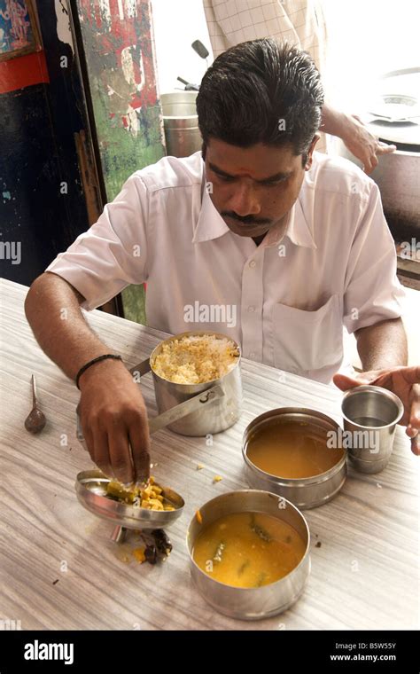 Man eating rice with sambar and vegetable curry from his tiffin box (lunch box) in Pondicherry ...